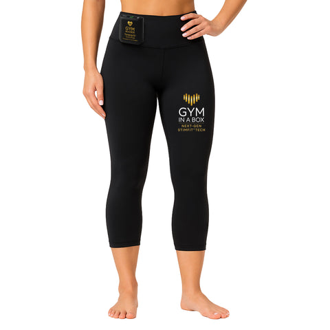 Black leggings with 'Gym in a Box' branding on a white background, Female model wearing black GYM IN A BOX® StimFit E-Pants with ToneUp15® controller attached at waistband and gold logo printed on thigh, front studio view.