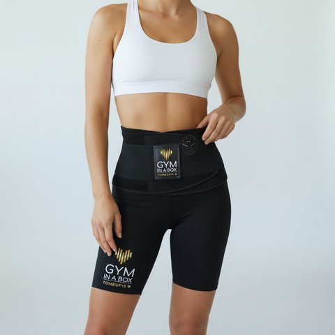 Person wearing a black waist trainer with 'Gym in a Box' branding on a light gray background